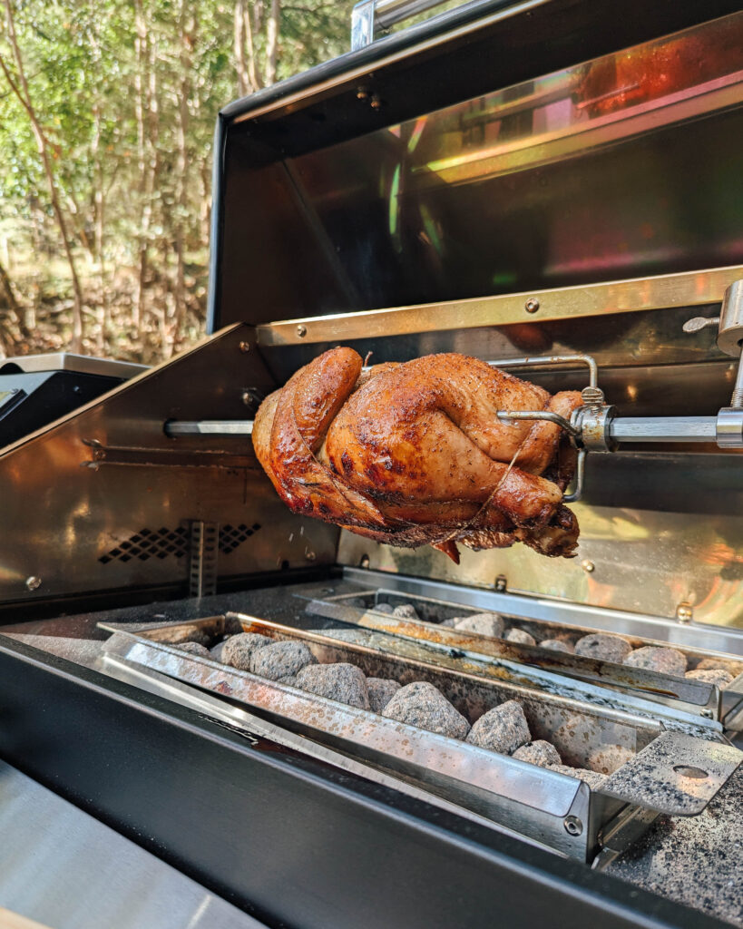 Chicken cooking on the Trimal S1 rotisserie above charcoal